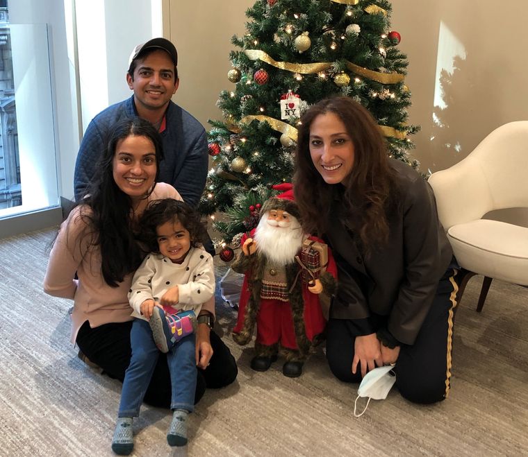 Dr. Elassar with a family and their little girl by a holiday tree