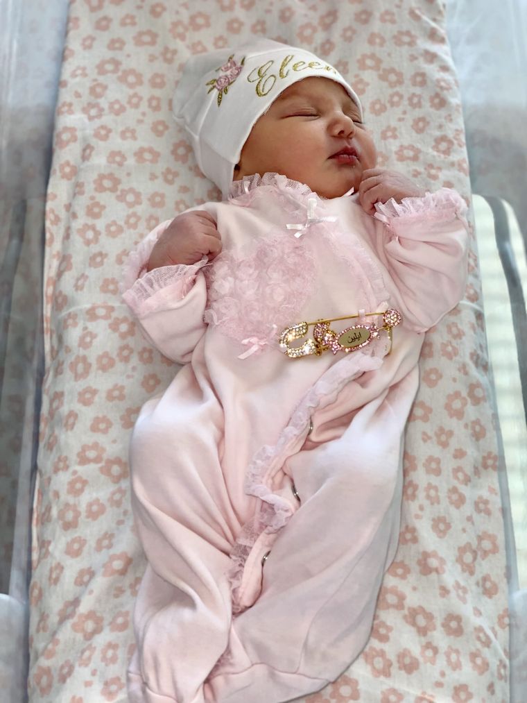 A sleeping newborn in a pink outfit