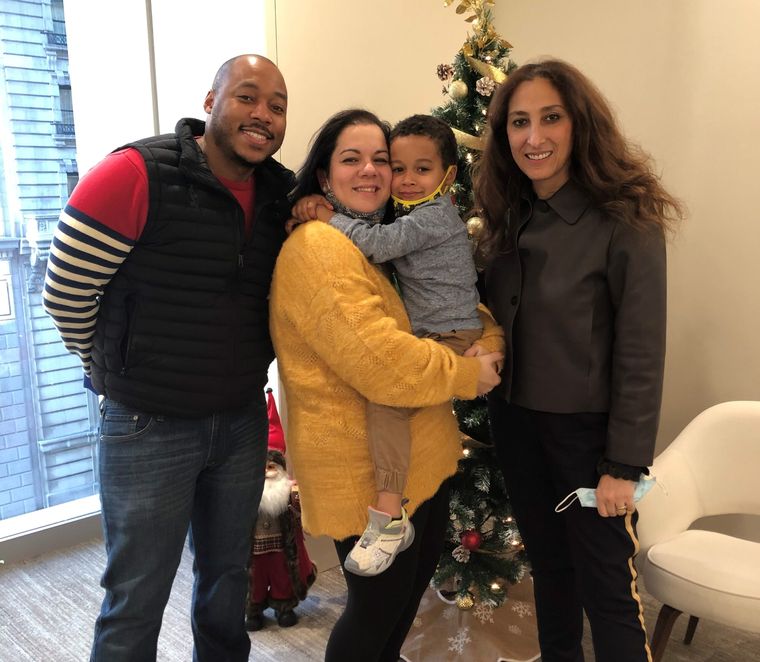 Dr. Elassar with a family and their toddler by a holiday tree
