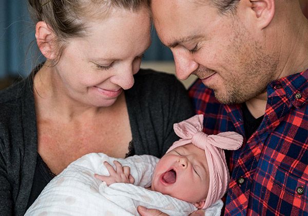 Parents cuddling their newborn daughter