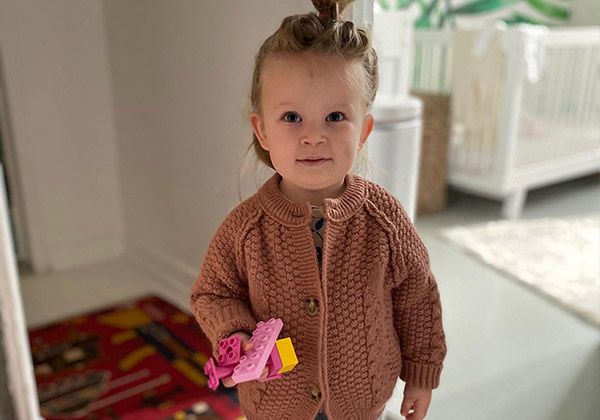 A toddler in a knit sweater