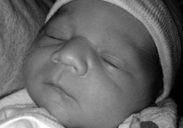 A sleeping newborn, in black and white