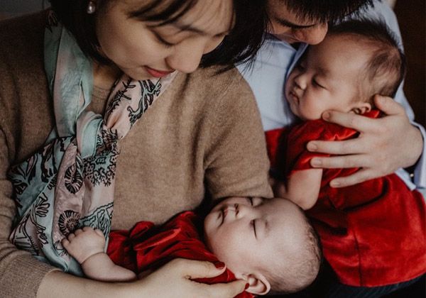 Parents holding their two babies close
