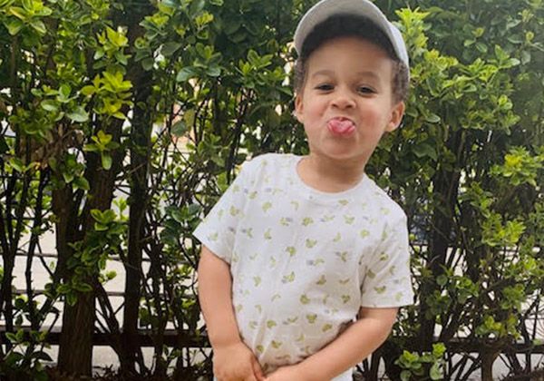 A toddler sticking out his tongue outdoors