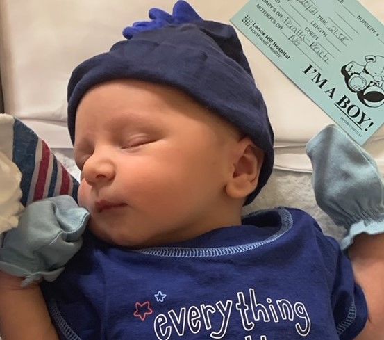 A sleeping newborn in a blue hat