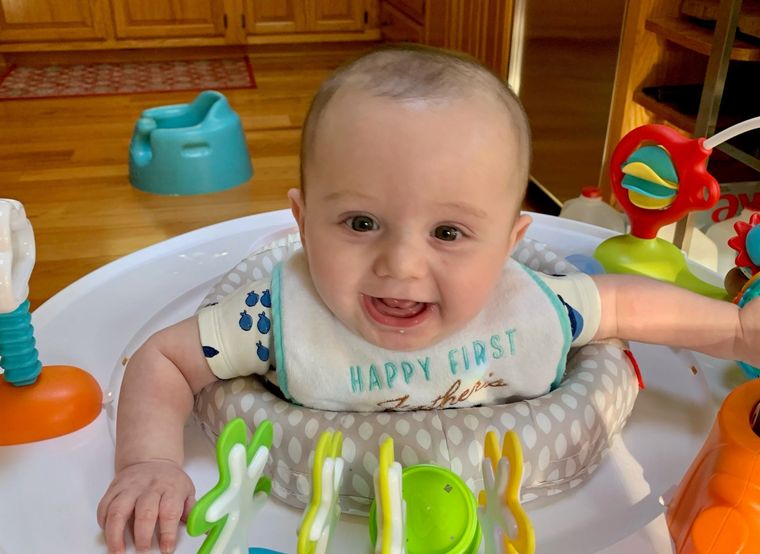 A smiling baby in a bouncer