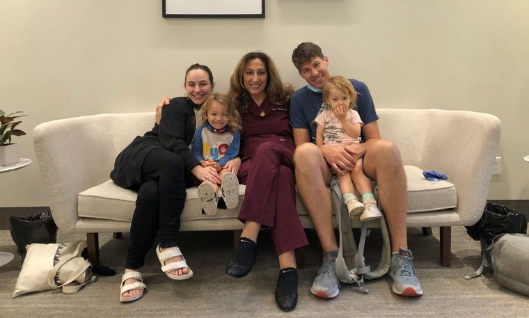 Dr. Elassar with a family and their two children on a sofa